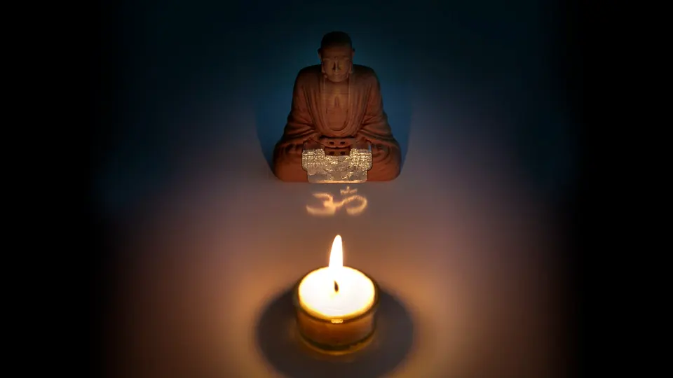 Photo of a Buddha figure projecting the Om Symbol